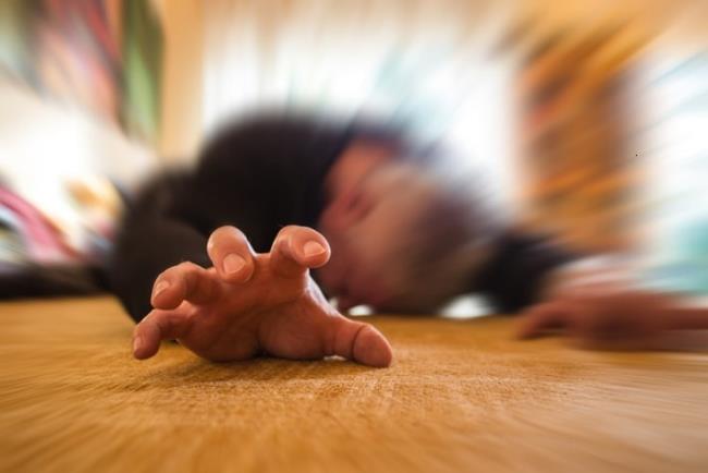 תקריב של יד גבר שוכב העובר פרכוס על הרצפה, טופיראמאט